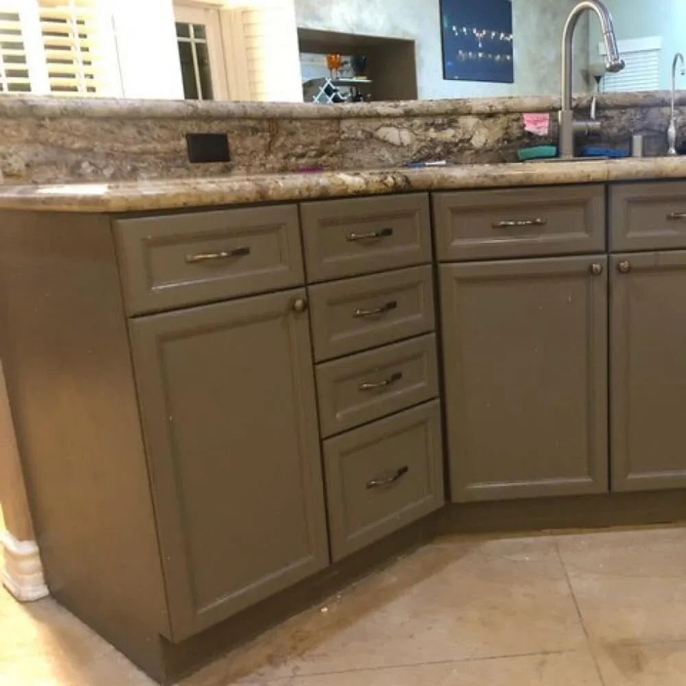 Kitchen cabinets repainted taupe with new handles and a pull-down faucet